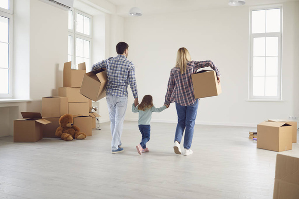 Familia feliz con niños moviéndose con cajas en una nueva casa de apartamentos
. - Foto, Imagen