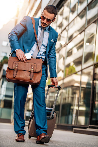 Бізнесмен з валізою в залі аеропорту
 - Фото, зображення
