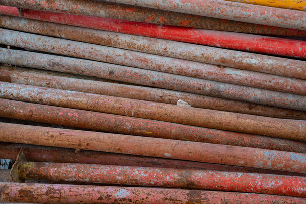 Pozadí obraz barevné lešení tyče a dřeva používané pro stavbu stohované dohromady - Fotografie, Obrázek