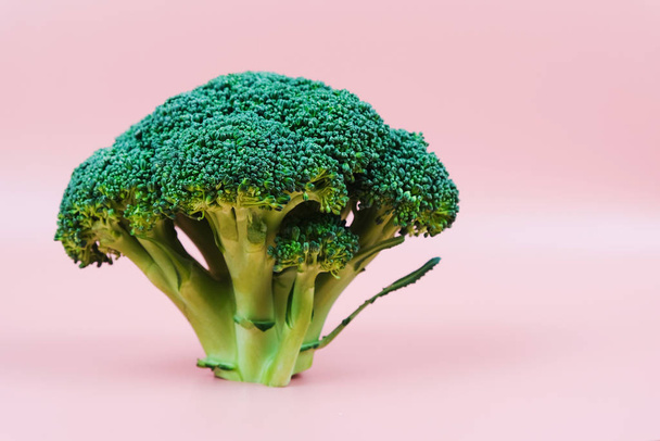 Fresh green bio broccoli on a pink background. Close-up - Zdjęcie, obraz