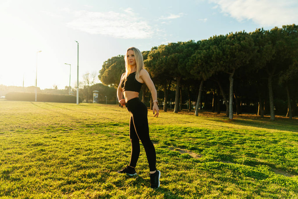 Sport training in city park. Beautiful runner woman posing - Zdjęcie, obraz
