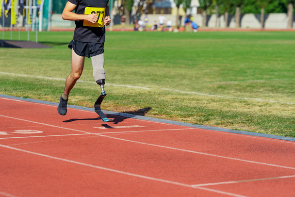 Amputee athlete running on a stadium track - Photo, image