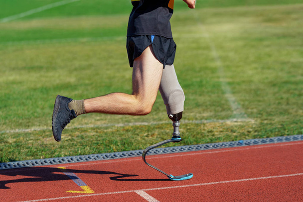 Amputee athlete participates in a race. Man with prosthetic leg - Fotó, kép