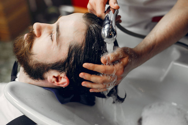 Стильный мужчина сидит в парикмахерской
 - Фото, изображение