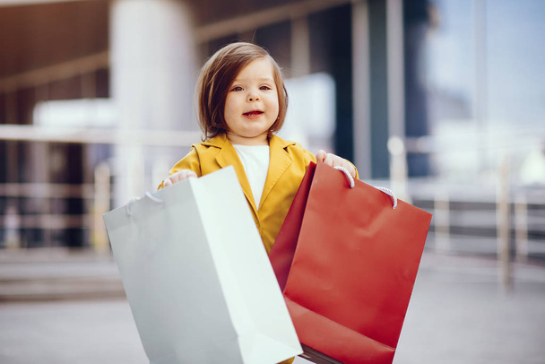 Cute little girl with shopping bag in a city - Foto, afbeelding
