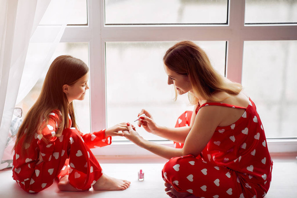 Cute mother and daughter at home in a pajamas - Valokuva, kuva