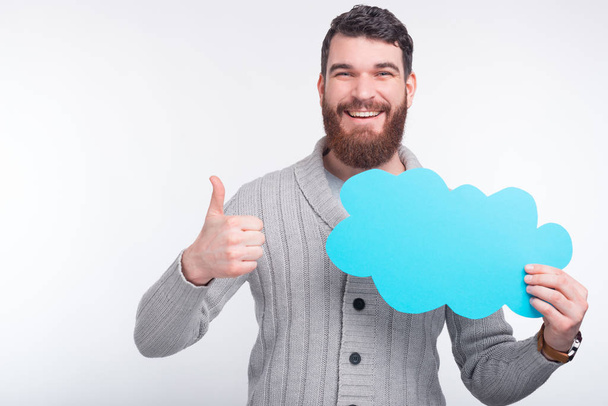 I like this option, opinion or offer. Smiling guy shows thumb up gesture while holding a light blue cloud. - Photo, image