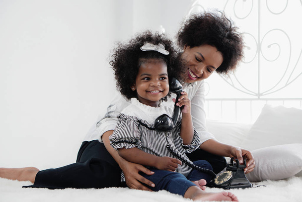 african american girl child enjoy playing telephone with her mot - Φωτογραφία, εικόνα