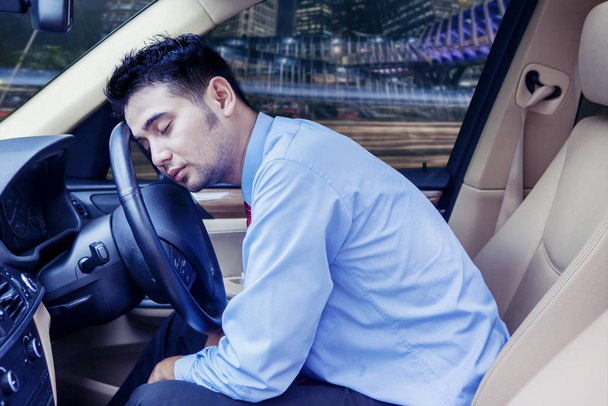 Young businessman sleeping inside his car - Foto, afbeelding