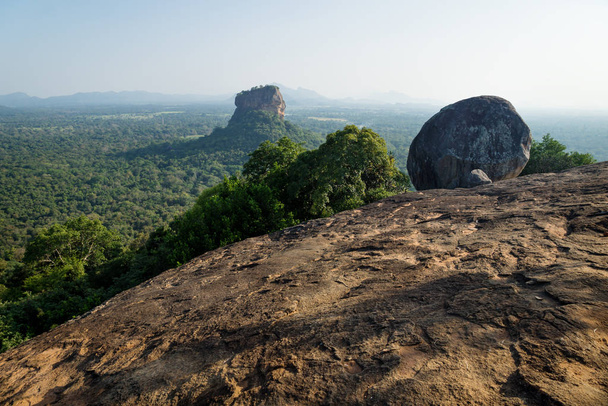 Big Stone on Pidurangala Rock with view on Lions Rock surrounded by forest in Sigiriya, Sri Lanka - Photo, Image