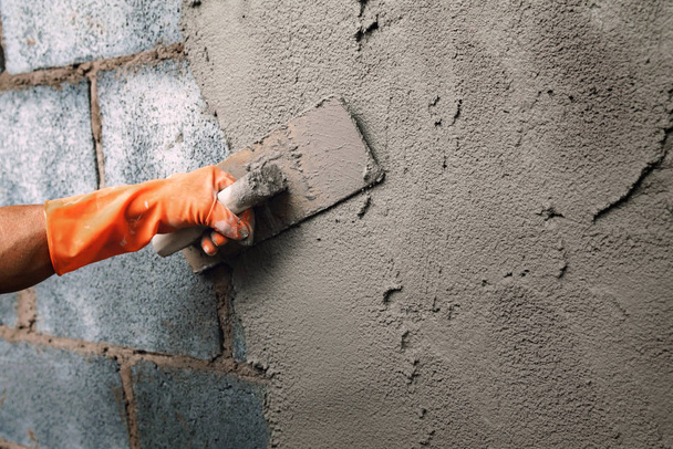 closeup hand worker plastering cement on wall for building house - Φωτογραφία, εικόνα