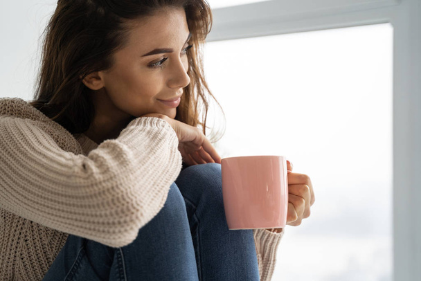 Pleased girl drinking a cup of tea - Foto, imagen