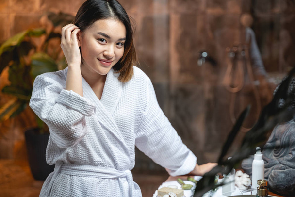 Viehättävä aasialainen nainen yllään valkoinen kylpytakki kauneushoitola
 - Valokuva, kuva