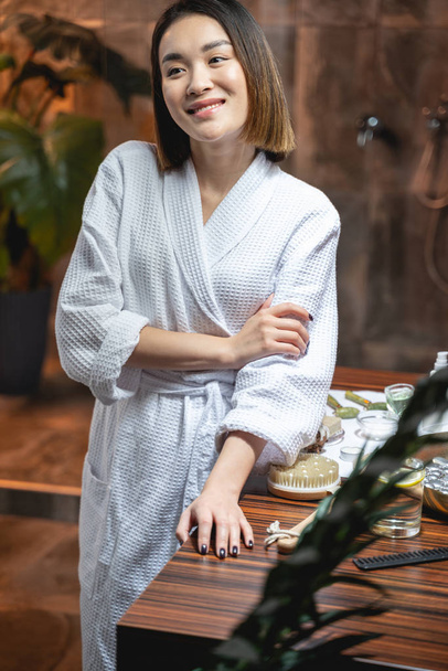 schattig aziatisch vrouw dragen wit badjas in schoonheid salon - Foto, afbeelding