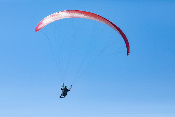 Paragliding. Paraglider flying in clear sunny day - Photo, Image