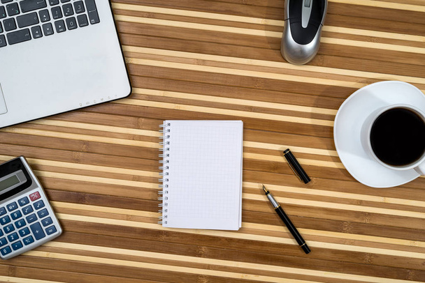 kantoor werkplek - laptop met koffie, pen en rekenmachine, Kladblok - Foto, afbeelding