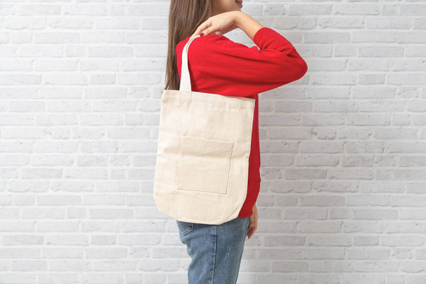 Womenl está sosteniendo tela de lona bolsa para maqueta plantilla en blanco
. - Foto, Imagen