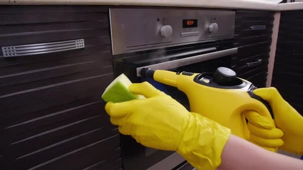 Koncepcja sprzątania domu. Mężczyzna sprzątanie kuchni z odkurzaczem parowym - Materiał filmowy, wideo