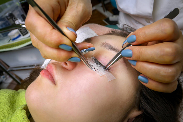 Eyelash extension procedure, woman eye with Long eyelashes - Fotoğraf, Görsel