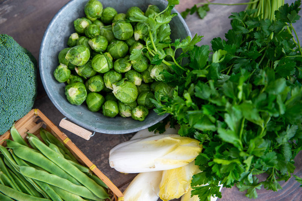 sprouts and endives on wooden background, Belgian vegetables - 写真・画像