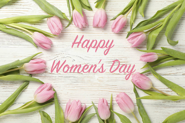 Inscription Happy Women's Day on wooden background with tulips - Foto, Imagen