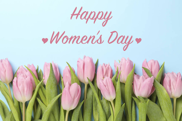 Inscrição Feliz Dia da Mulher em fundo azul com tulipas
 - Foto, Imagem