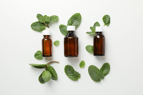 Medical bottles and mint on white background, space for text - Fotoğraf, Görsel