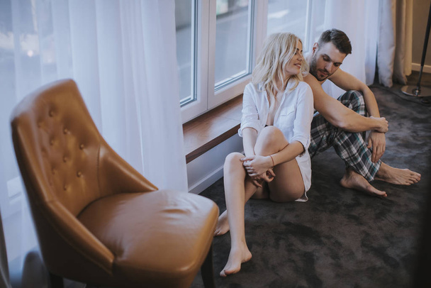 Young loving couple sitting on the floor in the room - Photo, Image