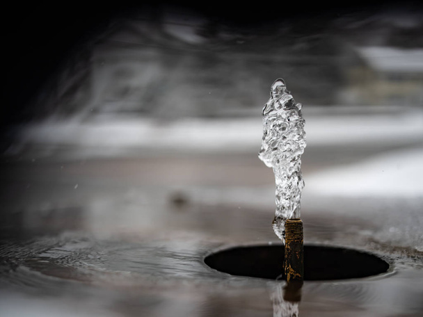 Το νερό εκρήγνυται από ένα μικρό Spigot με ένα όμορφο φόντο - Φωτογραφία, εικόνα
