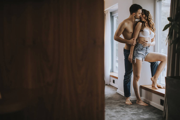 Jovem casal de pé no quarto do apartamento
 - Foto, Imagem