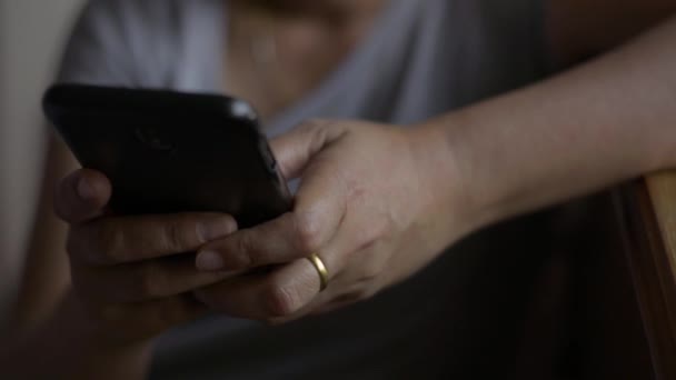 Cerrar mujer manos mensaje de texto en el teléfono inteligente móvil para la comunicación y el chat en línea social en el dormitorio
. - Metraje, vídeo