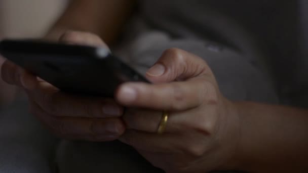 Закройте руки женщины смс сообщение на мобильный смартфон для общения и чата в социальных онлайн в спальне
. - Кадры, видео