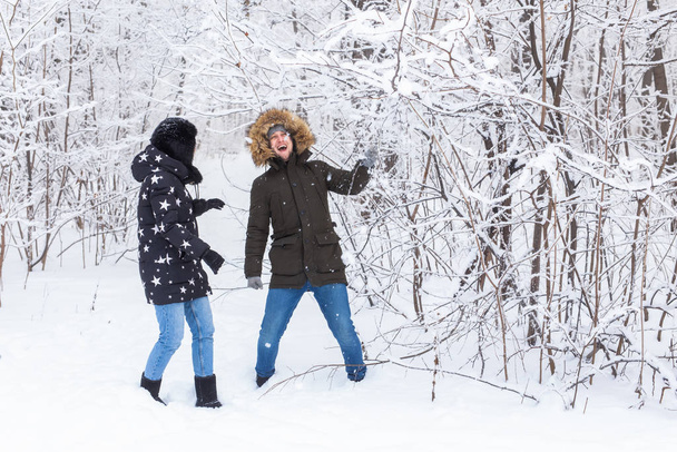 Genç aşık çift karlı ormanda eğleniyor. Aktif kış tatili. - Fotoğraf, Görsel