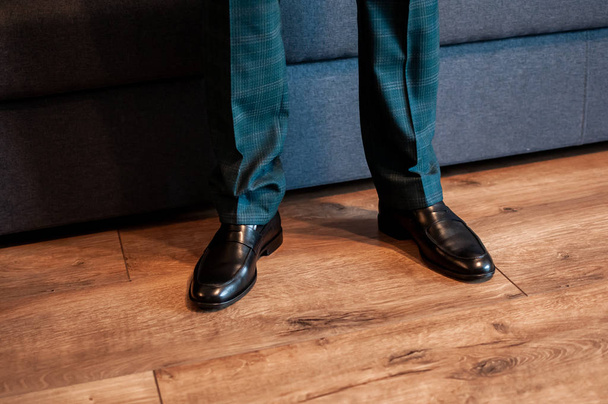 Темно-коричневе взуття на ногах
 - Фото, зображення
