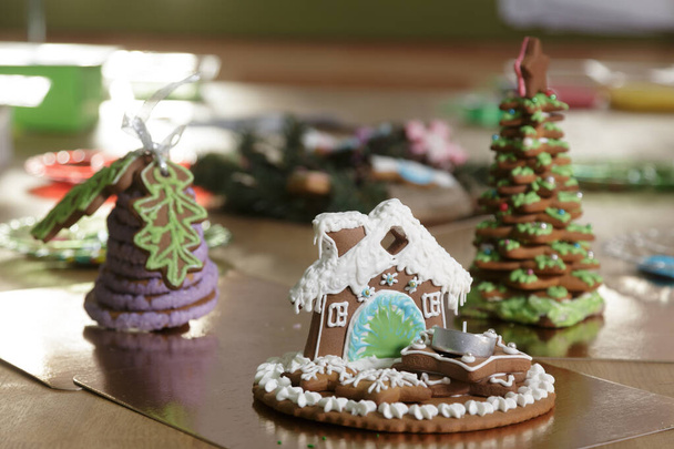Piernikowy dom, bożonarodzeniowa piekarnia, Gingerbread paleniska i domu urządzone kolorowe lukier. Świąteczne ciasteczko w kształcie domu. Piernikowe symbole świąteczne, ciasteczka. - Zdjęcie, obraz