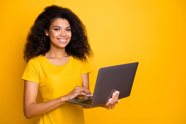 Close-up portrait of her she nice attractive lovely cheerful cheery wavy-haired girl holding in hands using laptop isolated over bright vivid shine vibrant yellow color background - Фото, изображение