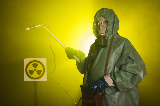 Radiation and danger concept - Man in old protective hazmat suit - Foto, Bild