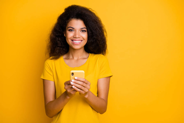Close-up portrait of her she nice attractive lovely cheerful cheery confident wavy-haired girl using gadget sending sms message isolated over bright vivid shine vibrant yellow color background - Foto, Bild