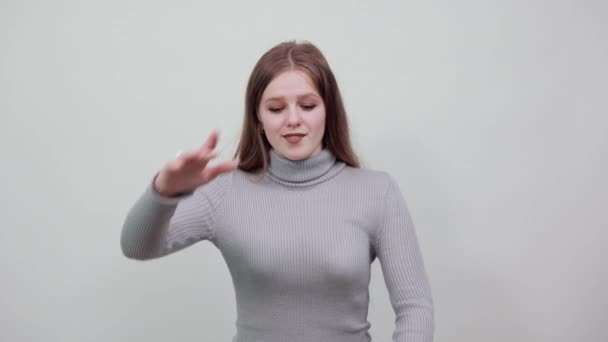 schöne rothaarige Frau im grauen Pullover zeigt Größe und Volumen des Pakets - Filmmaterial, Video