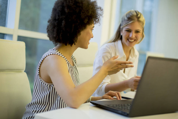 Femmes d'affaires multiraciales en réunion dans un bureau moderne remue-méninges, travaillant sur ordinateur portable
 - Photo, image