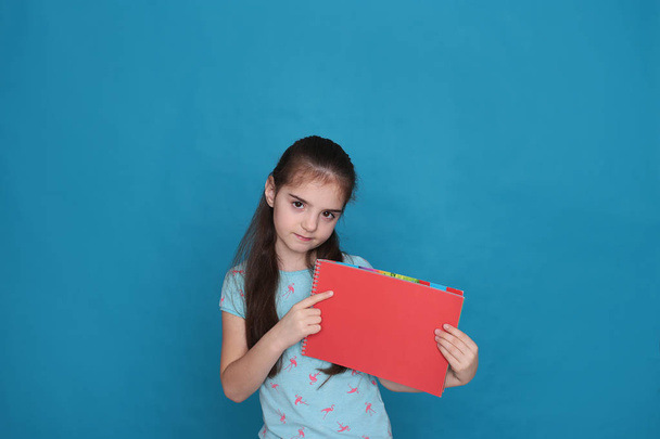 Весела любляча дівчина вісім років і кольоровий аркуш паперу вільний простір для запису на синьому фоні
 - Фото, зображення
