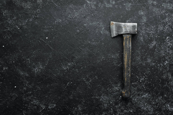 Old ax on a black stone background. Top view. Free space for text. - Foto, Imagem