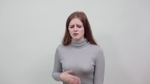 nő szürke pulóverben vörös hajjal fájdalmat érez a mellkasában, megérinti a fájó pontot - Felvétel, videó