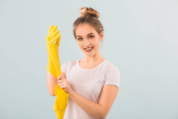 beautiful young woman in rubber gloves over blue background - Foto, Imagem