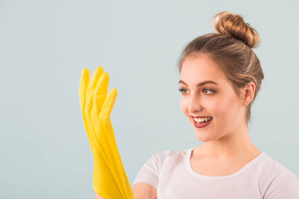 beautiful young woman in rubber gloves over blue background - Fotoğraf, Görsel