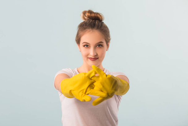 beautiful young woman in rubber gloves over blue background - Foto, imagen