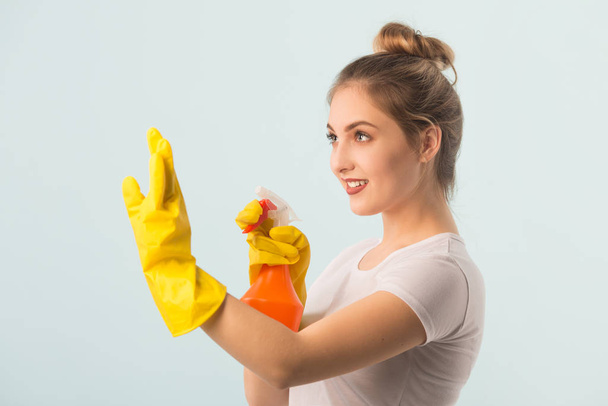 beautiful young woman in rubber gloves with a cleaning agent in her hands - Foto, Imagem