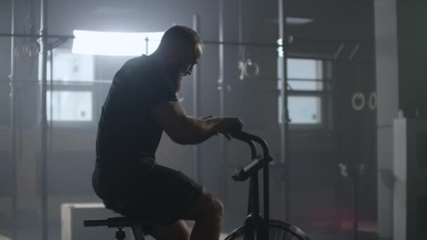 Cámara lenta: Hombre de fitness en bicicleta haciendo spinning en el gimnasio. Ajuste joven mujer haciendo ejercicio en bicicleta de gimnasio
 - Imágenes, Vídeo