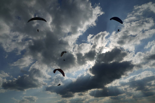 paragliders and dramatic clouds - Фото, изображение