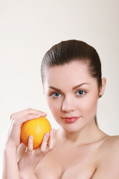 Young woman with orange isolated on white - Fotografie, Obrázek